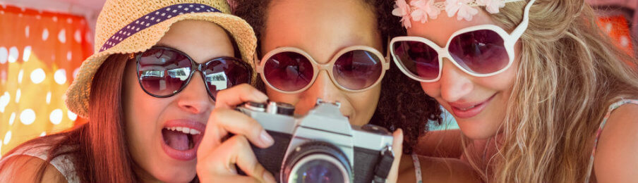 three young female travelers looking at the photos in the camera